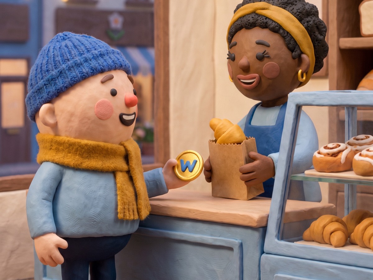 a clay baker handing a paper bag of pastries across her bakery counter to a smiling shopper